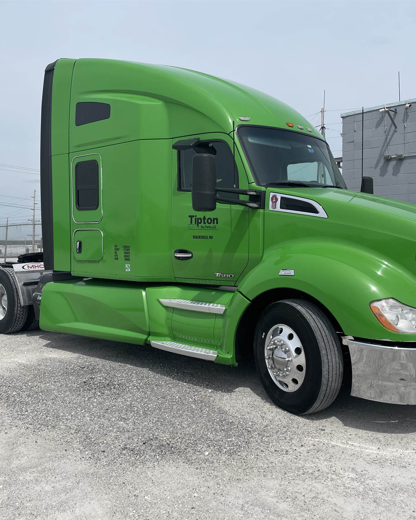 A green Tipton Hay Farms Kenworth T680, unit 015, parked at the shop